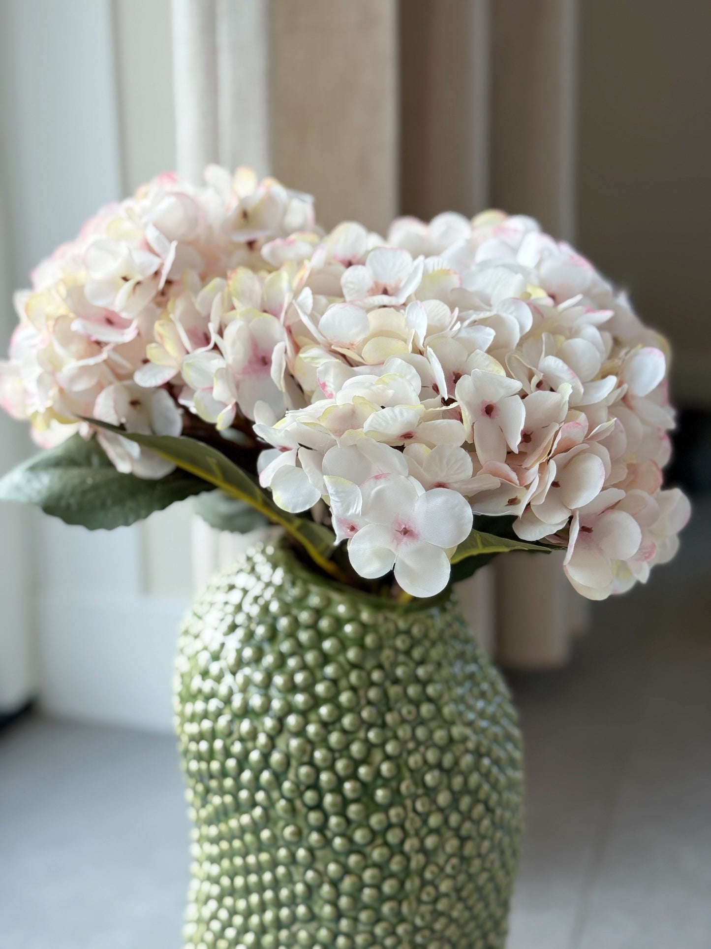 groene vaas met hortensia's