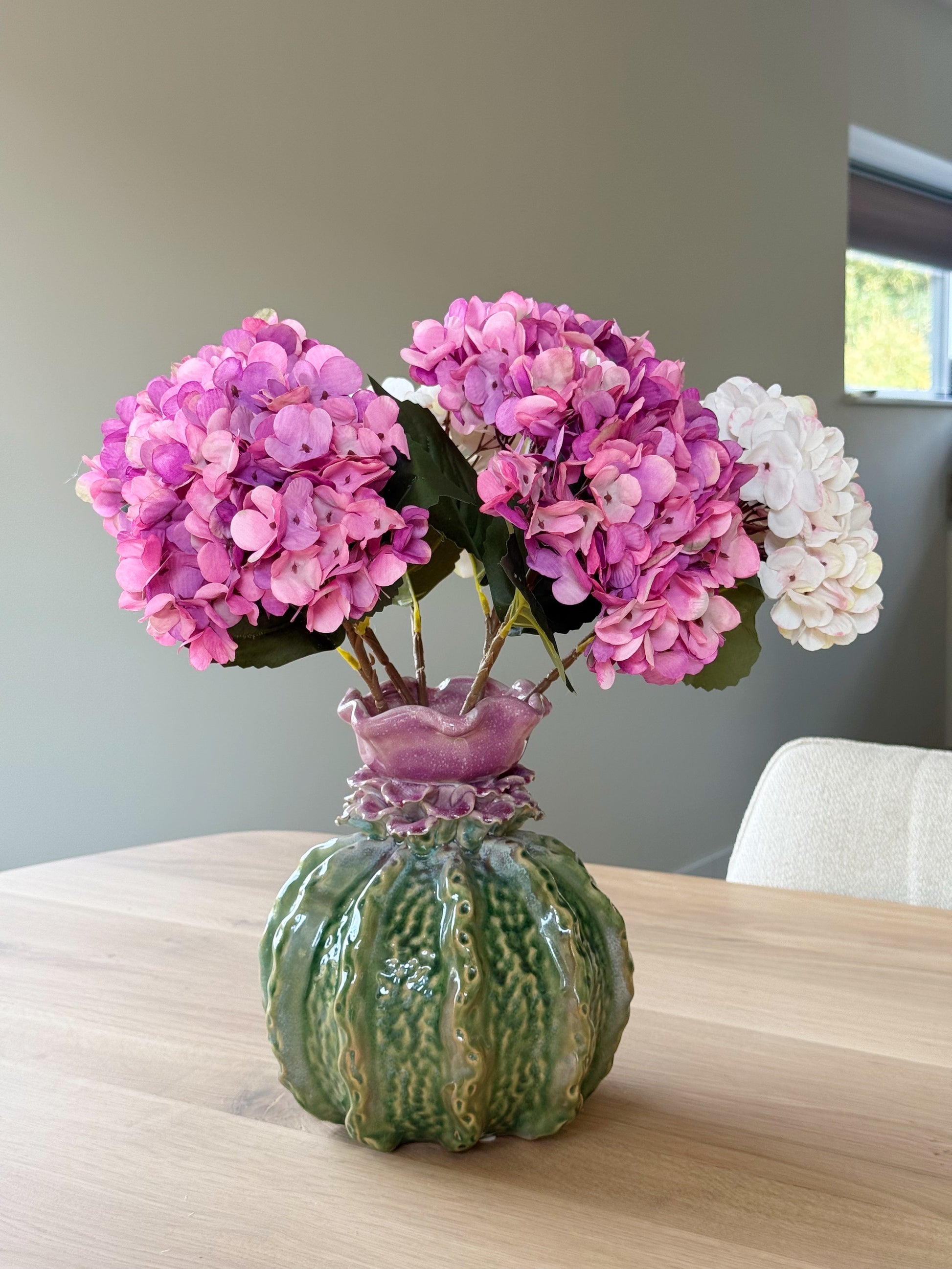 Groene vaas met roze hortensia's 