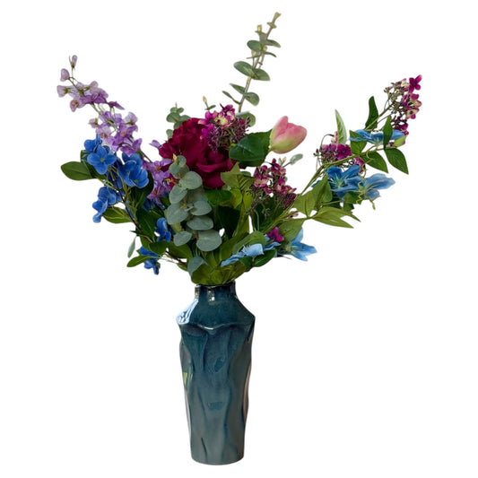 blauwe vaas met een boeket kunstbloemen