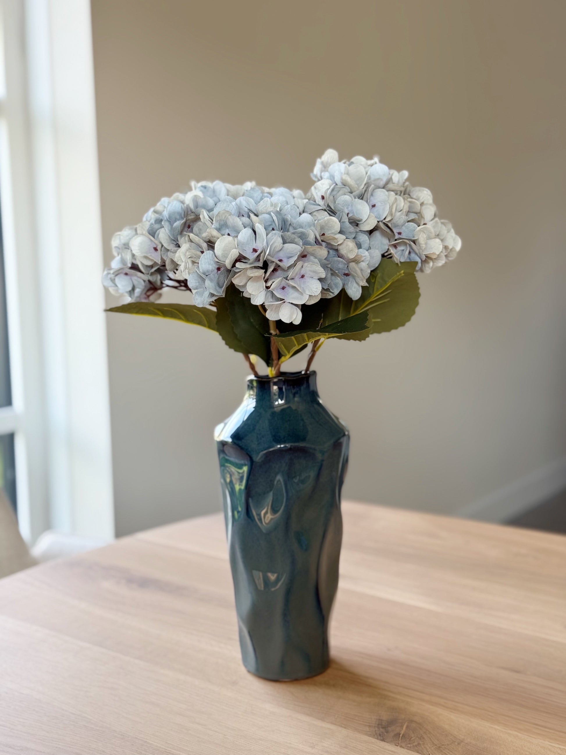blauwe vaas met een zijden bloemen boeket